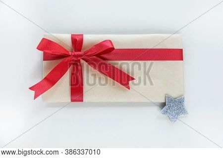 A Kraft Paper Envelope Tied With A Red Festive Ribbon Is Meant To Be A Gift For Christmas Or New Yea