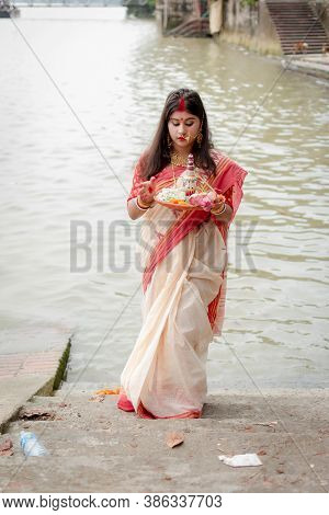Portrait Of Beautiful Indian Girl Wearing Traditional Indian Saree, Gold Jewellery And Bangles Holdi