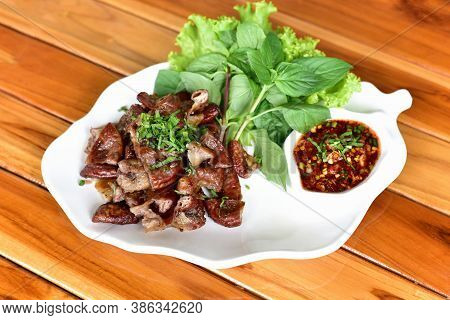 Roasted Pork Chitterlings With Chilli Sauce Spicy In A White Plate On A Wooden Tableor Grilled Pork 