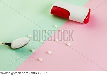 Sugar Substitute Tablets And Natural Sweetener Powder On A Green-pink Background.