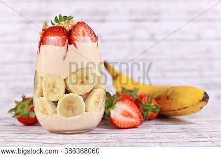 Healthy Banana And Strawberry Fruit Summer Dessert With Yogurt And Granola Layerde In Glass Surround