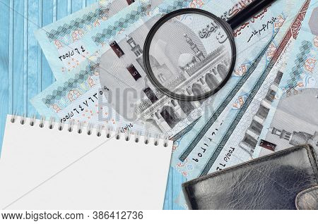 5 Egyptian Pounds Bills And Magnifying Glass With Black Purse And Notepad. Concept Of Counterfeit Mo