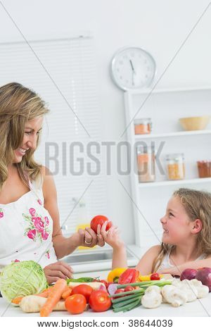 Fille donnant des tomates de la belle-mère la kithcen