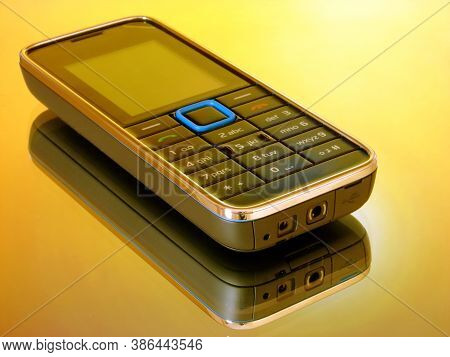 A Image Showing A Old Non Smart  Mobile Handset With Reflection & Nice Color Background.