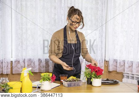 Lifestyle Beautiful Female Gardener With Face Stained With Soil Listening Music, Having Fun In Home 