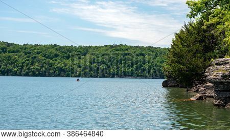 An Unidentified Person Enjoys A Peaceful Day Of Calm Kayaking On A Beautiful Scenic Lake In Oklahoma