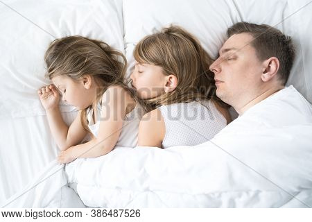 Kids, Dad Sleep Together In Bed On Pillows Under Blanket. Family Joint Sleeping. Father With Cute Li