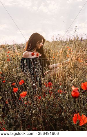 Nature Harmony. Beautiful Young Brunette Woman In Off Shoulders Black Dress Sitting In Profile In A
