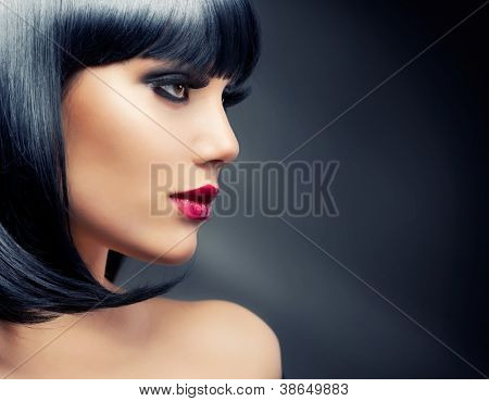 Bella donna bruna ritratto su sfondo scuro. Sani capelli neri