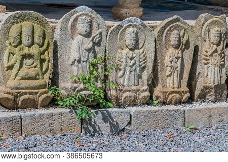 Geumsan, South Korea; September 12, 2020: Rock Carved Monks On Brick Base Of Structure At Dongguksa 