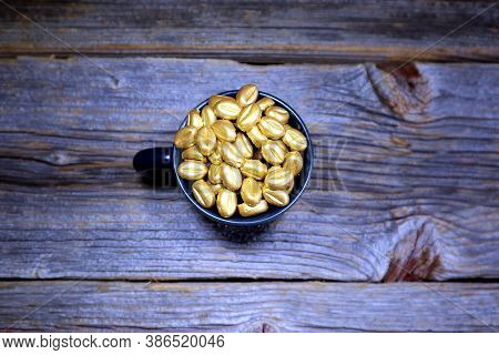 Golden Coffee Beans In A Ceramic Espresso Cup On A Wooden Board