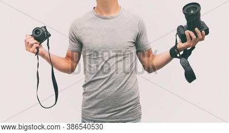 The photographer is holding in one hand dslr camera and mirrorless in another one. 