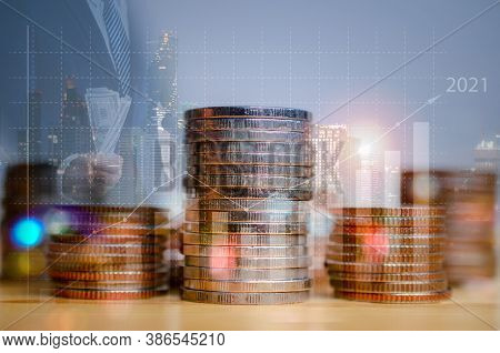 Double Exposure Of Graph And Rows Of Coins On City Night Background.finance And Business Concept.