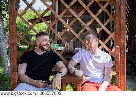 Happy Smiling Male Friends Resting Outdoors, Two Handsome Guys Sitting On Back Yard Of Coutry House,