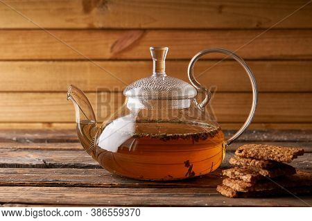 Teapot With Brewed Hot Tea And Homemade Cookies On A Wooden, Cozy Background