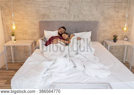 Beautiful Young Couple In Love Wearing Pajams, Lying In Bed Covered With Duvet, Sleeping Together Hu
