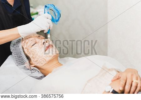 Woman Having Stimulating Facial Treatment At Professional Clinic.