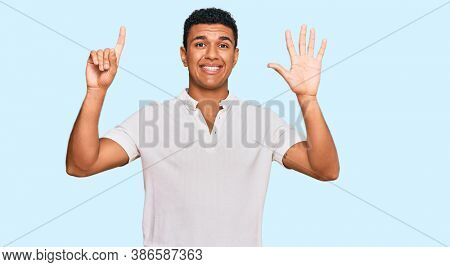 Young arab man wearing casual clothes showing and pointing up with fingers number six while smiling confident and happy. 