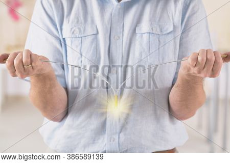 Man dowsing wirh dividing rod to locate ground water under surface or currents of earth radiation to check home for safe zones.