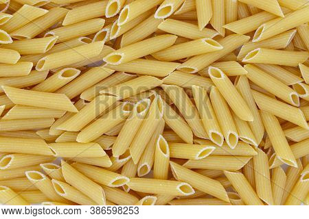 Penne Flat Lay. Pasta Secco Photo Texture. Dry Pasta Penne Scatter Top View. Whole Wheat Food For Ga