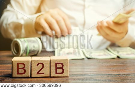 Wooden Blocks With The Word B2b And Businessman. A Business Enters Into A Commercial Transaction Wit