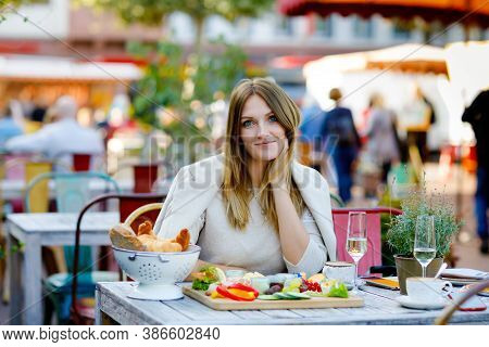 Young Beautiful Woman Drinking Coffee And Having Breakfast While Waiting For Friend. Happy Alone Wom