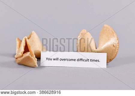 Motivational Text On Paper Saying 'you Will Overcome Difficult Times' Next To Fortune Cookies On Gra