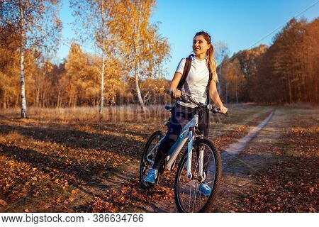 Riding Bicycle In Autumn Forest. Young Woman Having Rest After Workout On Bike Enjoying Nature. Heal