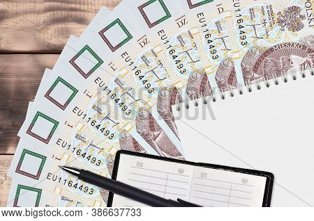 10 Polish Zloty Bills Fan And Notepad With Contact Book And Black Pen. Concept Of Financial Planning