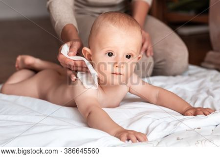 Hygiene - Young Mom Wiping The Baby Skin Body With Wet Wipes Carefully. Mother Changing The Baby Nap