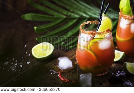 Michelada - Mexican Alcoholic Cocktail With Beer, Lime Juice, Tomato Juice, Spicy Sauce And Spices, 