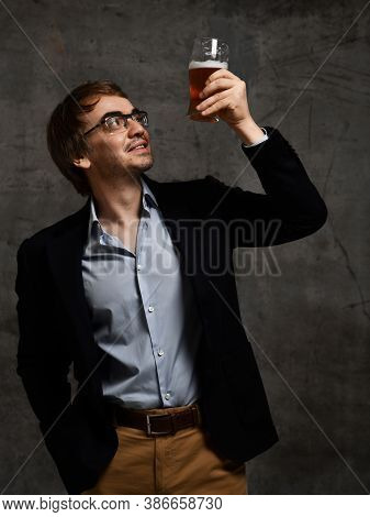 Contentedly Smiling Middle-aged Man In Stylish Official Clothing Jacket And Shirt Holds Up A Glass O