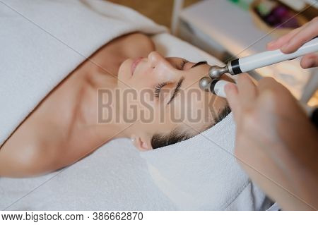 Lateral View Of Woman Facial Massage Spa Procedure. Electric Stimulation Facial Skin Care. Microcurr