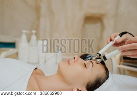 Lateral View Of Woman Facial Massage Spa Procedure. Electric Stimulation Facial Skin Care. Microcurr