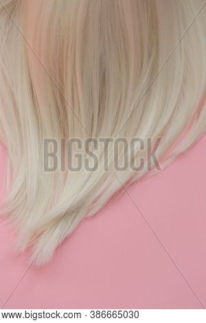 Blond Hair . Blond Hair Texture. A Lock Of White Hair On A Light Pink Pastel Background.hairdressing