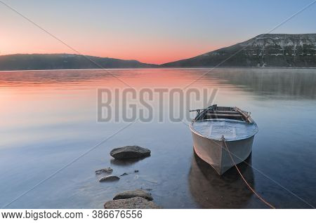 The Fishing Rowing Boat Is Moored To The Shore Of The Reservoir