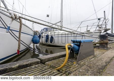 A Jacht Is Charging In Marken, Netherlands, Electrical Outlets For Charging Ships In The Harbor