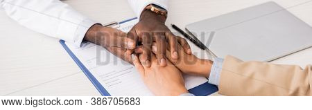 Cropped View Of African American Doctor Touching Hands Of Patient Near Clipboard With Insurance Form
