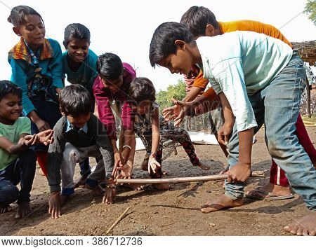 District Katni, India - January 01, 2020: Asian Poor Village Children Playing Gilli Danda Together A