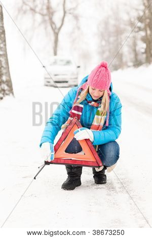Donna mettendo il segnale di pericolo triangolo auto ripartizione inverno neve
