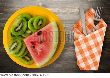 Watermelon And Kiwi Sliced On A Yellow Plate Or A Black Wooden Background .watermelon And Kiw With F