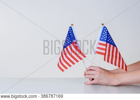 Amamerican Flags In Hands On A Light Background Over The Tableerican Flags In Hands On A Light Backg