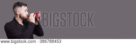Caucasian Man With Beard Blowing Intro A Holiday Hat Posing Near Free Space Near Him Gesturing A New