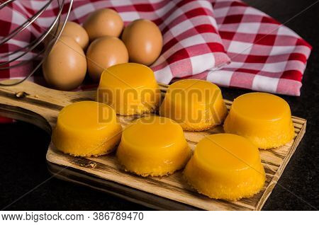 Delicious Quindins On Wooden Board, Traditional Brazilian Dessert Made With Egg Yolk, Sugar And Coco