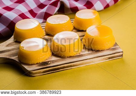 Delicious Quindins On Wooden Board, Traditional Brazilian Dessert Made With Egg Yolk, Sugar And Coco