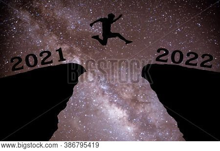 A Young Man Jump Between 2021 And 2022 Years Over Night Sky With Stars And Through On The Gap Of Hil
