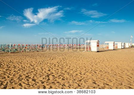 roten und weiÃŸen Sonnenschirmen und Sunlongers am Sandstrand