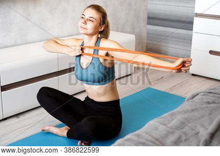 Woman At Home Trying To Lose Weight And Have Training With Elastic Band In Her Hands