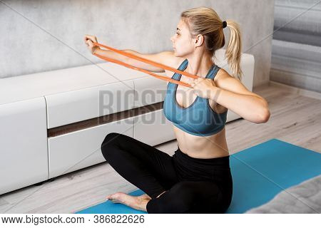 Woman At Home Trying To Lose Weight And Have Training With Elastic Band In Her Hands