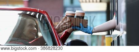 Woman In Convertible Car Picks Up Tea And Coffee In Mcdrive. Fast And Safe Service In Restaurants An